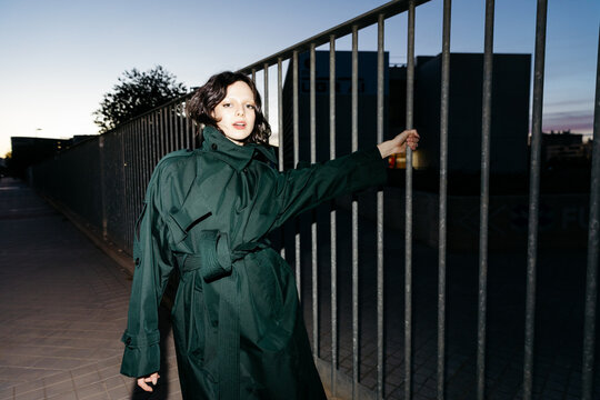 Woman in the street wearing a green trench coat