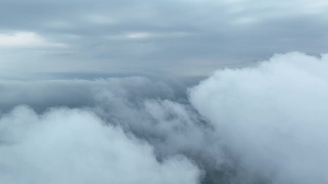 Aerial view flying through moody overcast clouds