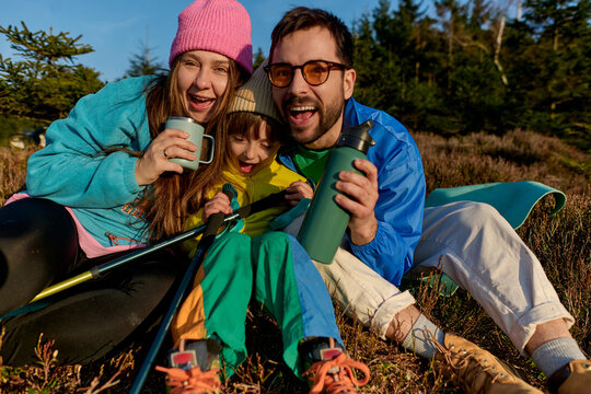 Happy family enjoying drinks during camping trip