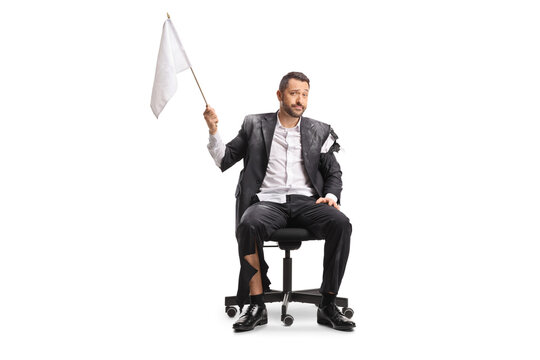 Businessman in torn clothes sitting on an office chair and waving a white flag