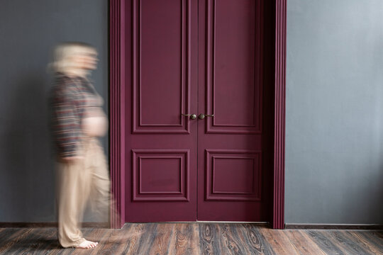 A pregnant woman approaches closed doors.