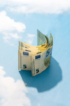 Curved five euro banknotes on sky background