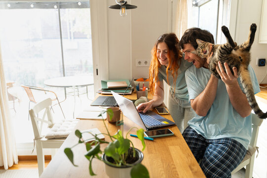 Couple Enjoys Time Together With Cat While Working at Home