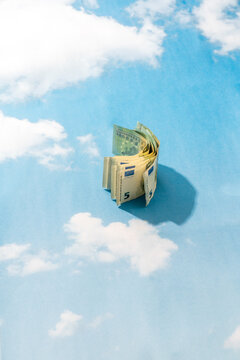 Rolled euro banknotes on sky background