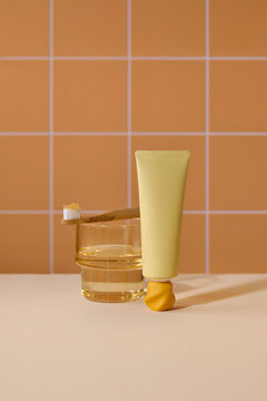 a yellow tube of toothpaste, a bamboo toothbrush with paste