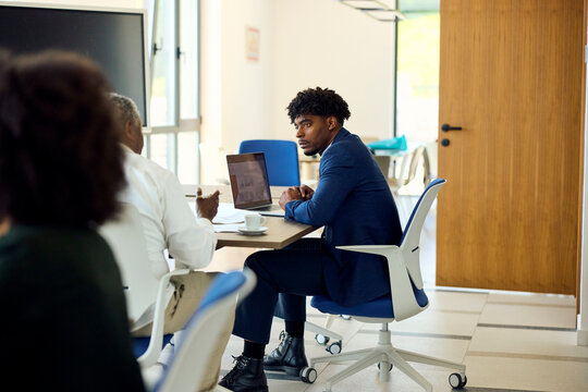 Two Men Discussing Work in a Shared Office