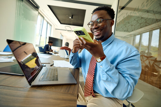 Businessman sits at a desk in a shared office, uses his phone