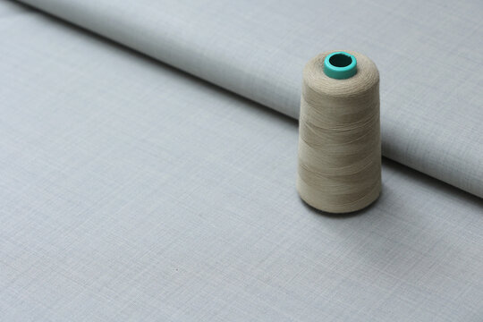 Premium light gray Super 180s wool suiting fabric featuring an elegant sharkskin weave, classic pick-and-pick texture, and a sophisticated micro-check pattern with thread atop for luxury tailoring.