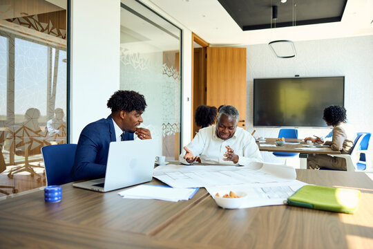 Two Men Discussing Plans in an Office Space