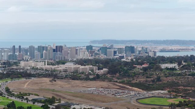 Southern California cityscape featuring San Diego downtown skyline, Balboa Park, Coronado Island peninsula with Pacific Ocean waters visible from above