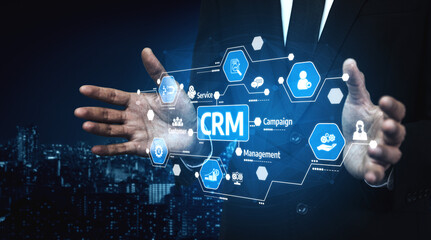 Fototapeta premium Businessman using innovative CRM technology to enhance customer relationship management with data visualization and digital connections in a modern cityscape. Tessel.