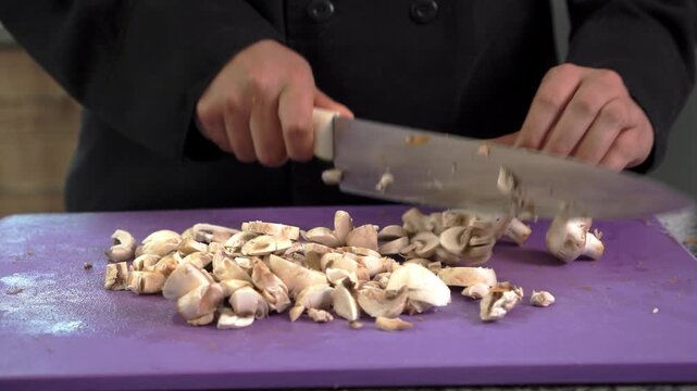 Professional chef skillfully slicing fresh mushrooms