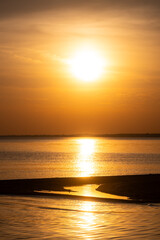 Obraz premium Sunset over a quiet shoreline.