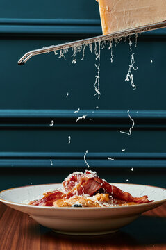 Parmesan cheese being grated onto the Cezar salad 