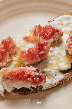 Slices of figs on a bread with cottage cheese and honey