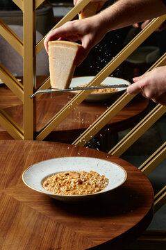 Man grating parmesan on the risotto