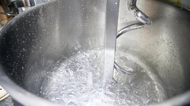 Ice cubes added to water in a stainless steel dough mixer for preparation