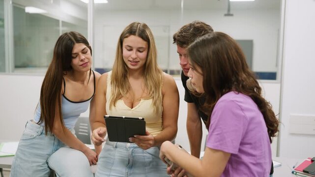 Young diverse students collaborating on project with tablet in classroom