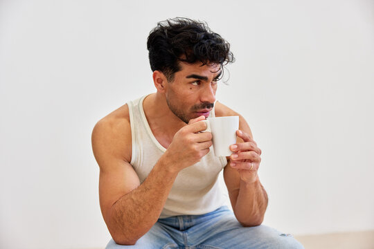 Man drinking coffee in casual clothes at home during day