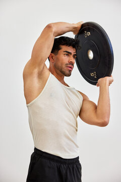 Man lifts weight indoors for workout and strength training
