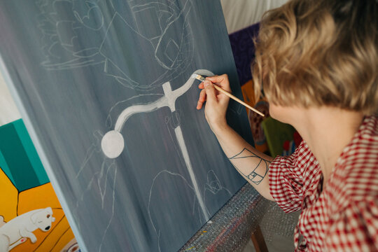 Woman artist painting on canvas in studio