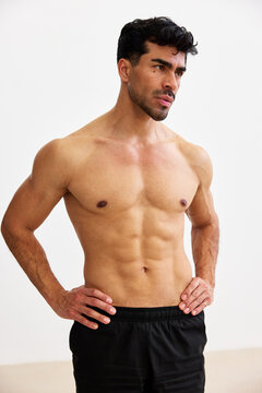 Man posing with hands on hips in workout setting