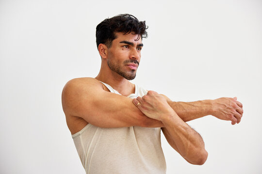 Man stretches arms in a simple indoor setting