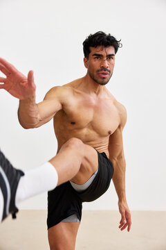 Man stretching indoors while exercising in a fitness studio
