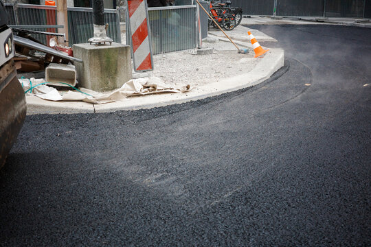 Freshly Laid Hot Asphalt with Steam Rising After Steamroller Passing