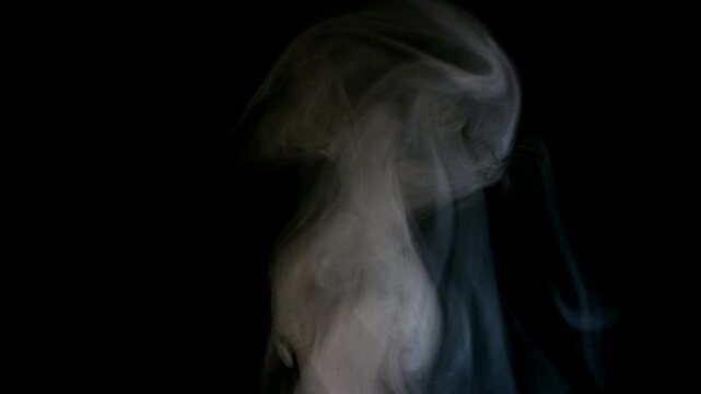 Abstract white smoke rising against a dark black background creating a mysterious and atmospheric visual effect.