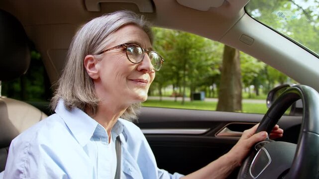 Positive Caucasian retired senior woman driving luxury car in city concentrated safety rules drive on road old aged female enjoy auto rental service granny lady smile inside comfortable automobile
