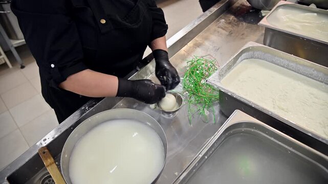 Burrata production process, woman shaping cheese in commercial kitchen setting