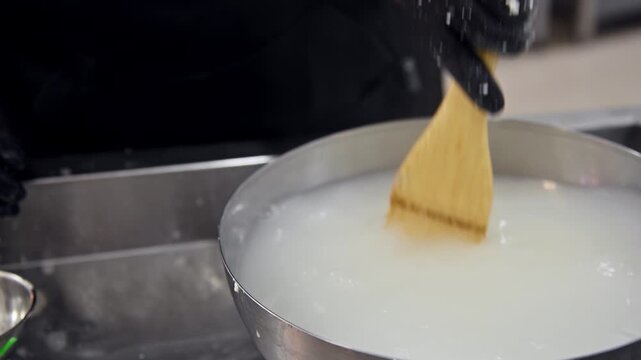 Mixing stracciatella ingredients in bowl with wooden spoon, close-up action