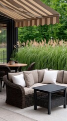 Fototapeta premium Spacious outdoor patio features light gray sectional sofa, coffee table, and dining area with large glass door in bright natural light