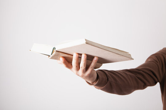 Young man reading a book on a white background. Education concept.