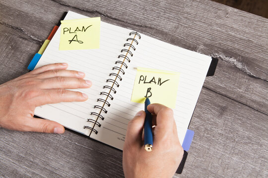 Plan A Plan B text on notepad and man's hand writing on it
