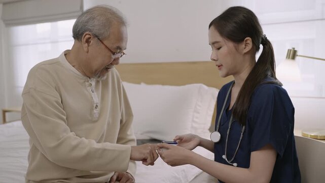 Professional Asian woman nurse using fingertip pulse oximeter exam on senior man patient in hospital room. Elderly sitting on nursing bed while female cardiologist measure blood oxygen and heartbeat. 