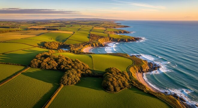 Panoramic Aerial View of the Stunning Cornish Coastline at Golden Hour with Rolling Green Hills, Sandy Beaches, and Crashing Ocean Waves