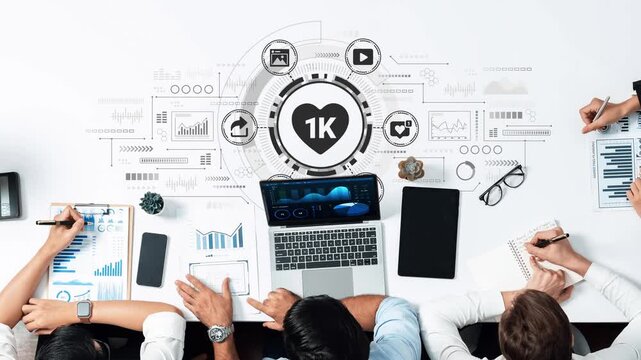 Diverse Team Analyzing Data and Metrics on Desktop with Digital Graphics and Icons Representing Analytics and Social Media Engagement. Entropy.