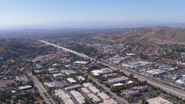 Los Angeles County urban panorama revealing suburban valley and Santa Monica Mountains with San Fernando Valley in background and freeway transportation