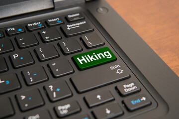 Obraz premium Close up of a computer keyboard with a green hiking key, representing outdoor adventure, trekking, healthy lifestyle, nature exploration, travel planning, and recreational activities.