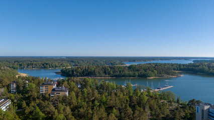 Fototapeta premium Aerial drone view of residential apartment buildings surrounded by pine forest and sea in Uusikaupunki