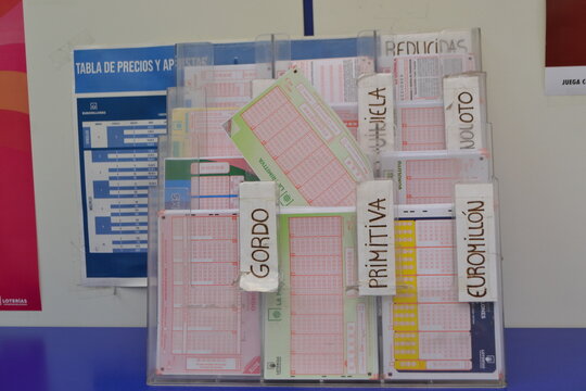 MADRID, SPAIN - JUNE, 4, 2026. Lottery ticket dispensers with assorted betting slips and labels for loterias y apuestas display and informational poster for spain retail