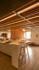 Obraz premium Modern kitchen island with wooden ceiling and warm ambient lighting