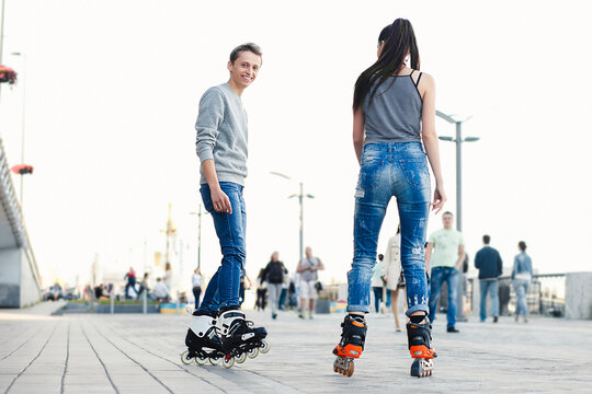 Young couple rollerblading outdoors enjoying active city life