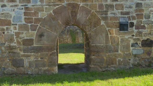 Stone archway entrance into a historic castle courtyard wall gate masonry