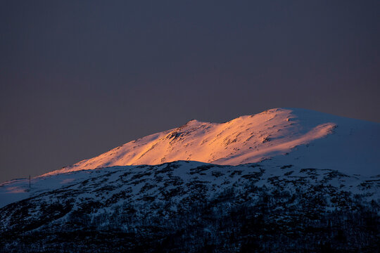 Beautiful golden sunlight shining on snowy mountain peaks. A springtime scenery near Geiranger Unesco World heritage area, Sunnmore, More og Romsdale, Norway.