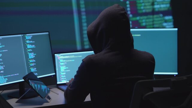 Anonymous Hacker Programming on Dual Monitors in a Low-Light Environment