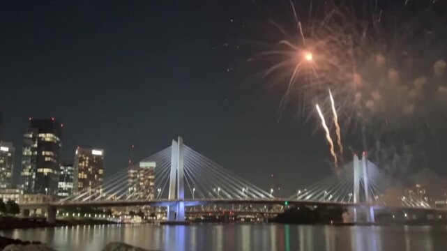 Tilikum crossing bridge in portland, oregon at night with fireworks display over the willamette river