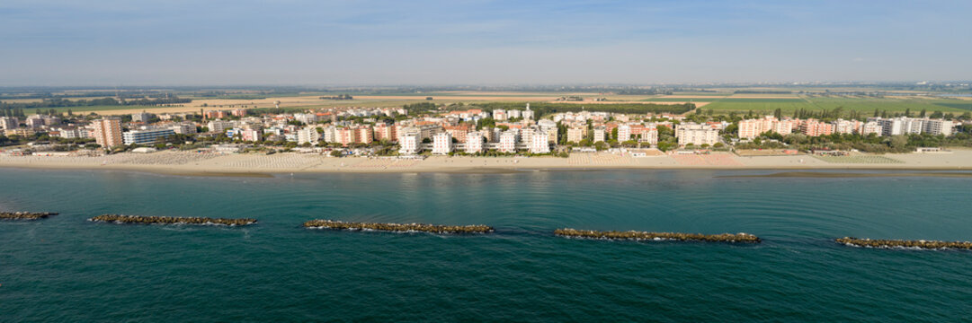 Panorama shot of sandy beach with umbrellas and gazebos.Summer vacation concept.Lido Adriano town,Adriatic coast, Emilia Romagna,Italy.